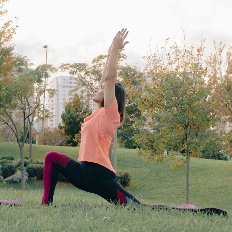 Person stretching gracefully in a sunlit room, embodying flexibility and peace.